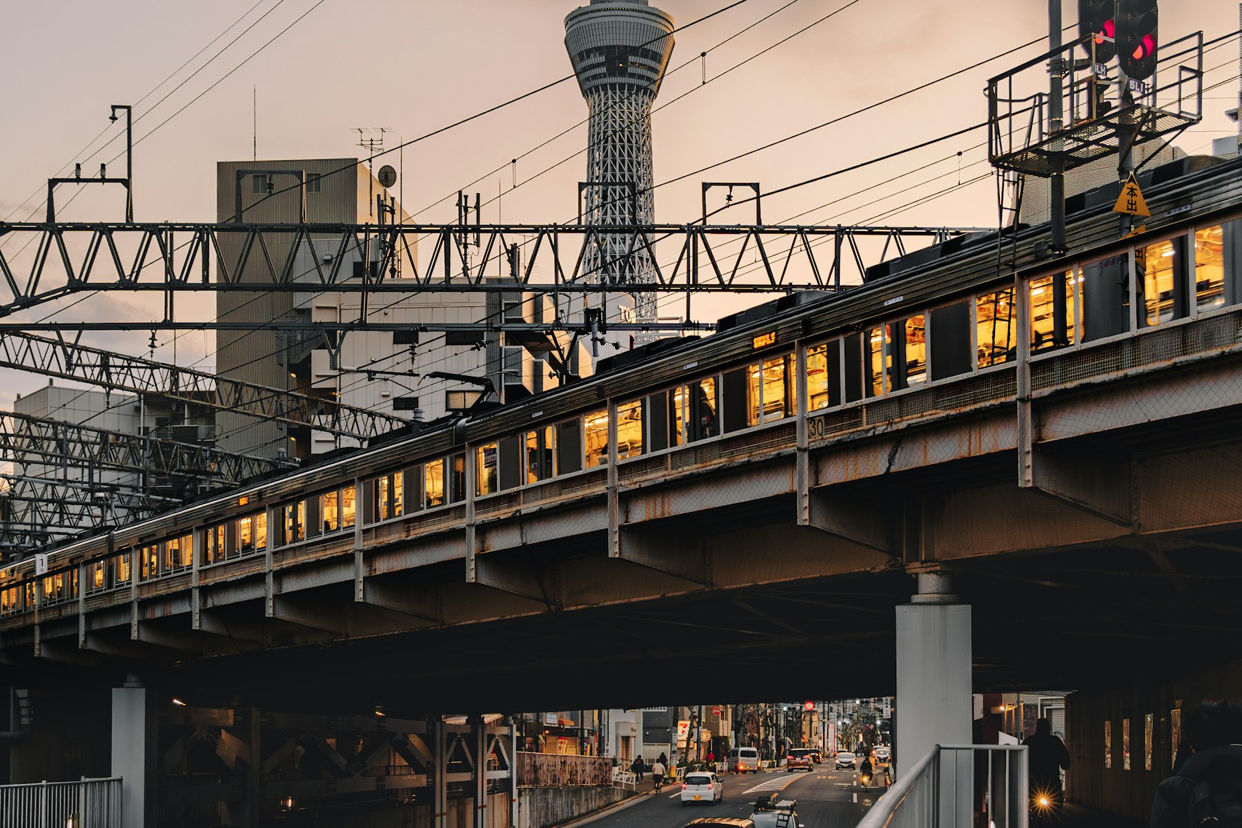 電車と通りの向こうに立つ東京スカイツリー